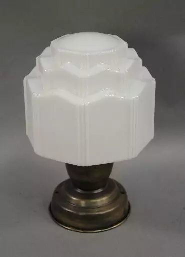 A lamp with a white shade on top of it.