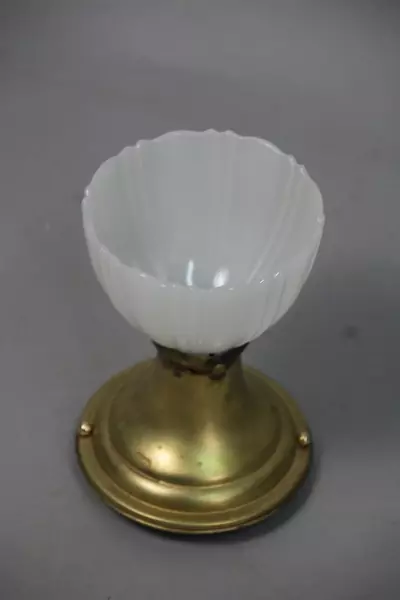 A white cup sitting on top of a gold pedestal.