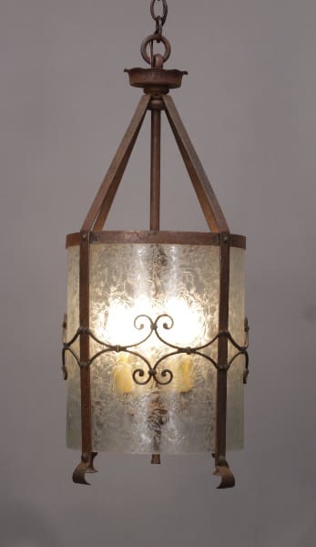 Antique 10395 Large Scale 1920's Iron Pendant with Original Glass with ornate metalwork and a single glowing bulb, suspended from a ceiling mount.