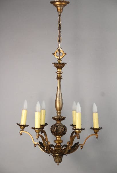 10489. Larger Scale 1920's 6-light Chandelier with five candle-like lights, detailed carvings, suspended from a chain against a gray background.