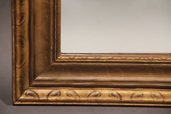 Close-up of the corner of a 11168. 1920's Mirror With Wood Gilt Frame displaying intricate ornamental patterns.