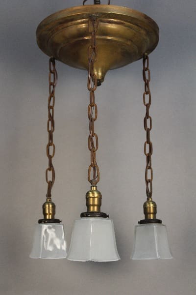 Three 11736. Arts And Crafts Period Chandeliers with frosted glass shades suspended by brass chains from a matching ceiling mount.