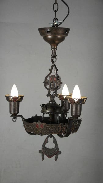 12047. 1920's Spanish Revival Polychrome Chandelier with ornate metalwork and three electric candles, hanging against a plain wall.