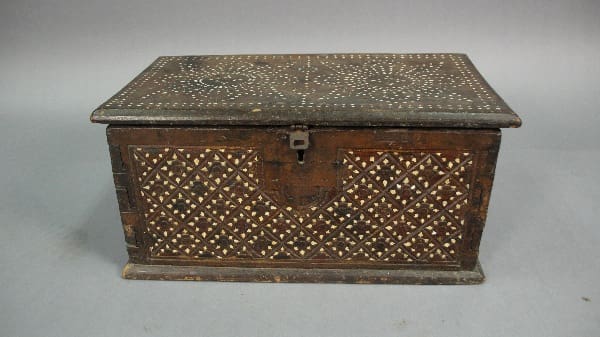 Antique 13432. 19th Century Small Trunk with intricate metal inlay and a front lock, placed on a gray surface against a plain background.
