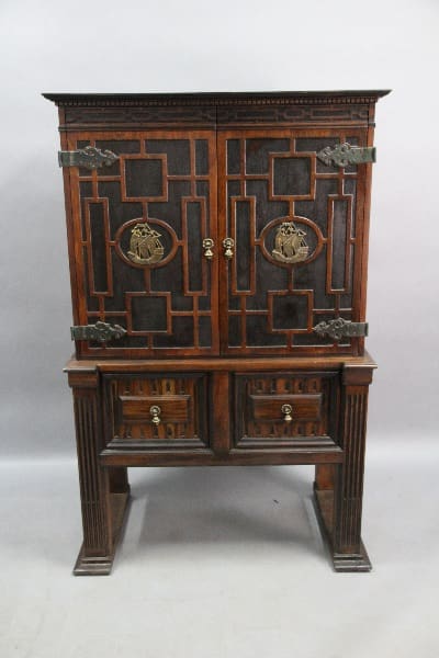 13824. Spanish Revival Walnut Cabinet With Iron Strapping with intricate metalwork, featuring upper double doors and a lower tier with small drawers, all set on a sturdy base.