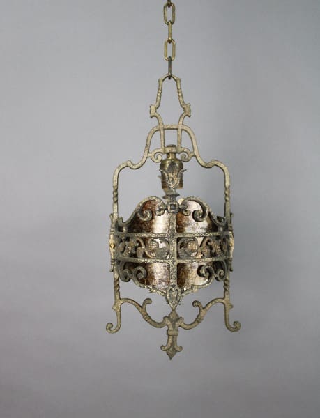 An ornate, 13920. 1 of 2 1920's Pendant With Thistle Motif with intricate scroll designs, hanging from a chain against a plain gray background.