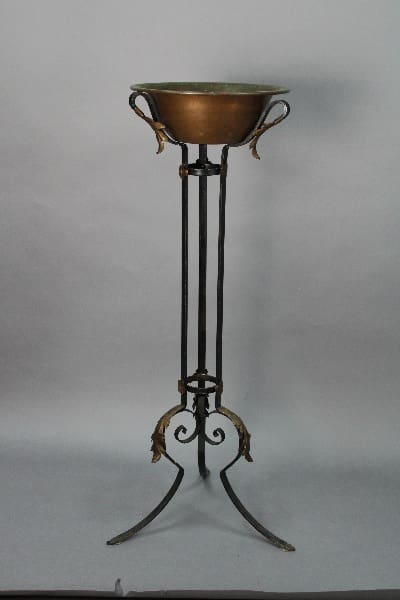 14066. 1920's Wrought Iron Plant Stand With Copper Bowl on a tall, wrought iron stand with decorative leaf motifs, against a plain gray background.