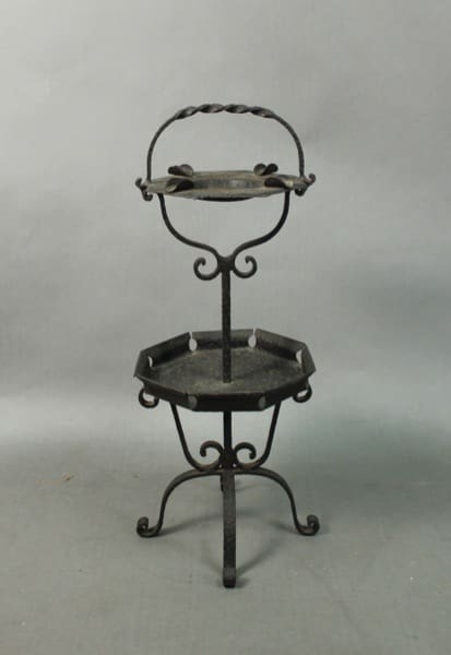 A two-tier Spanish Revival Iron Ashtray Cigar Ashtray stand, featuring a top circular tray with a handle and a lower larger tray, set against a grey backdrop.
