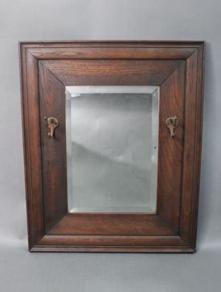 Antique small wood framed mirror with a central rectangular mirror, featuring two metal hooks on the lower edge.