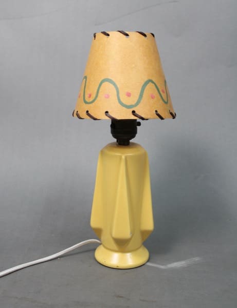 14279. Small 1920's Lamp With Pottery Base Attribute To Catalina with a yellow base and a patterned lampshade, featuring a plug-in wire, set against a gray background.