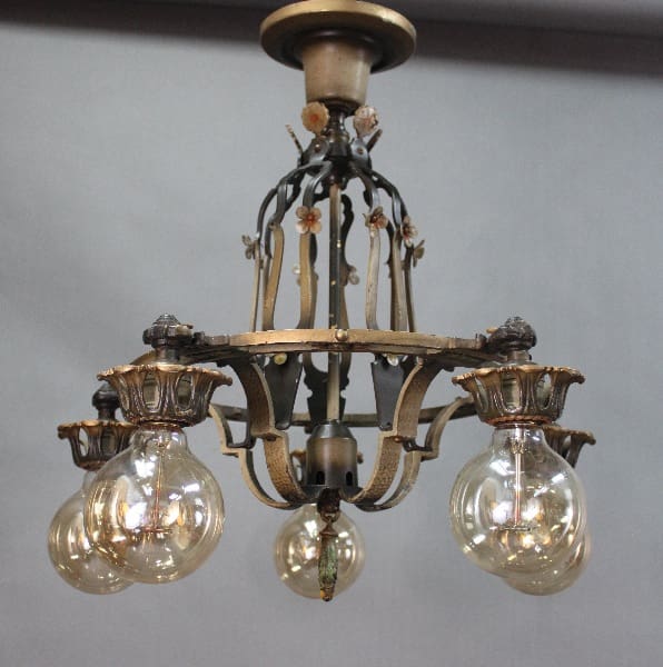 An antique 14527. 1920's 5 Light Chandelier With Original Finish with floral and lion motifs, holding four illuminated glass globes.