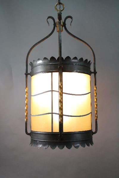 A hanging lantern with a 14568. Large 40" H 1920's Iron And Slag Glass Pendant, against a grey background.