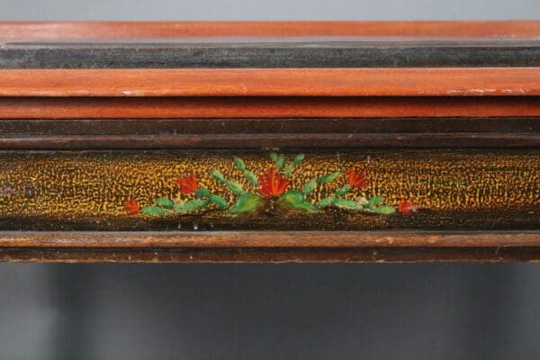 Close-up of a 14683. De Anza Hotel Desk With Tile featuring a detailed golden floral pattern on a textured surface with visible layers of wood framing above and below.