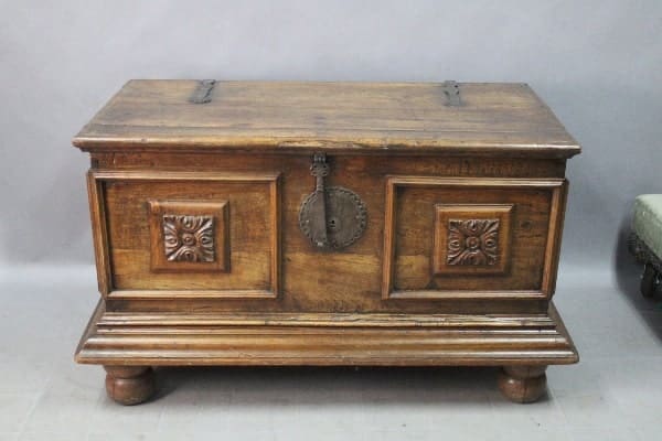 14851. 19th Century Walnut Trunk With Original Hardware with ornate carvings and a central metal ring on the front, resting on a slightly raised base.