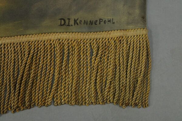 Close-up of fabric with yellow fringe and the 14879. Spanish Revival Hand Painted Mural And Rod embroidered in black thread.