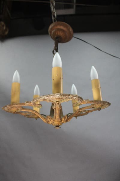 An antique 14922. Spanish Revival Chandelier Circa 1920's with five unlit candles hanging from a ceiling.