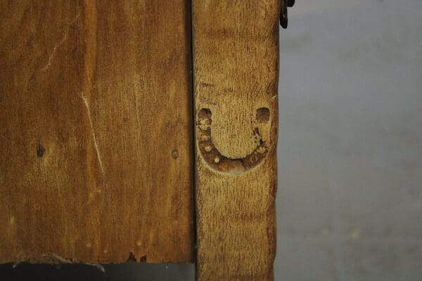 15010. Signed Monterey Desk With Original Iron Hardware with a distinct, smile-shaped mark, set against a grey concrete background.