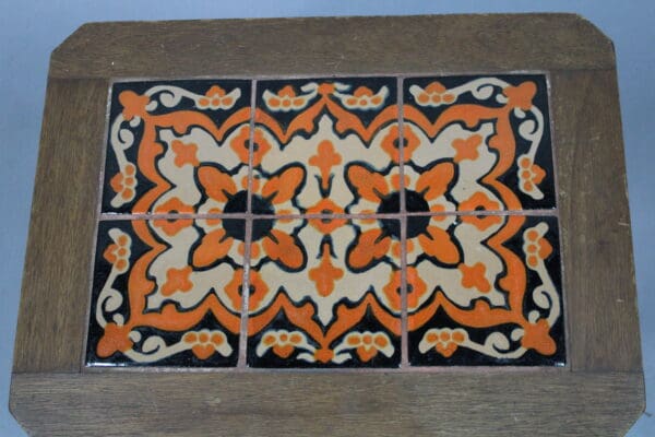 Six 15022. 1920's Early California Monterey Style Spanish Revival tiles with orange and black floral patterns mounted on a wooden frame against a plain background.