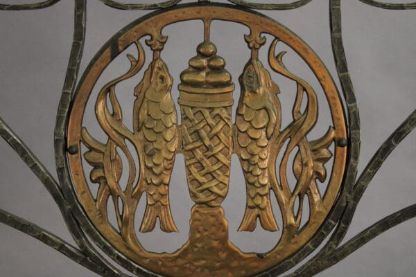 Decorative metalwork featuring two fish flanking an intertwined celtic knot design, all within an ornate circular frame, similar to the 15055. Outstanding Pair Of 1920's Iron And Bronze Candelabra in The Manner Of Oscar Bach.