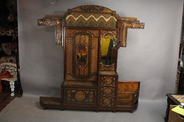 Antique Turn Of The Century Moorish Coat Rack with ornate carvings and inlaid designs, featuring a central mirror and multiple drawers.