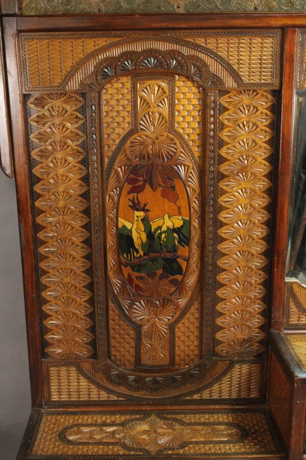 Antique 15109. Turn Of The Century Moorish Coat Rack with detailed carvings and inlaid floral motifs, featuring a central stained glass panel depicting a pastoral scene.