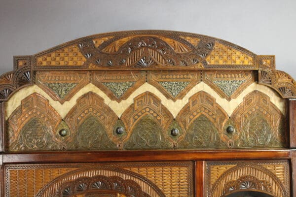 Ornate 15109. Turn Of The Century Moorish Coat Rack with intricate carvings and geometric patterns, featuring a combination of arches and diamond shapes in earth tones.