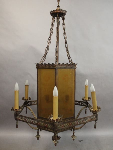 Antique 15240. 1 of 5 Large Scale All Original Spanish Revival chandelier with metal frame and panels, featuring four white candle-shaped bulbs, suspended by a chain.