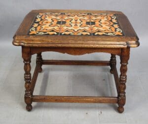 15317. 1920's Early California Monterey Style Spanish Revival Tile Table With 6 Tiles, featuring a square top with a decorative ceramic tile inlay in orange and black, supported by turned legs and a lower shelf.