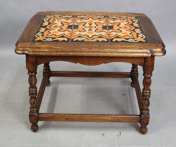 15317. 1920's Early California Monterey Style Spanish Revival Tile Table With 6 Tiles, featuring a square top with a decorative ceramic tile inlay in orange and black, supported by turned legs and a lower shelf.