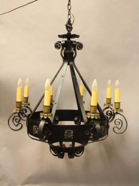 Black metal chandelier with yellow candles.