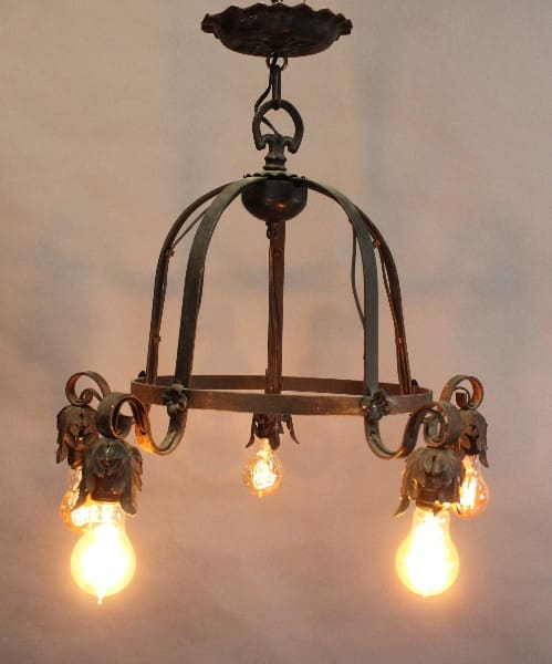 Vintage Spanish Revival 1920's Downlight chandelier with five illuminated bulbs, adorned with floral accents, hanging from a ceiling.