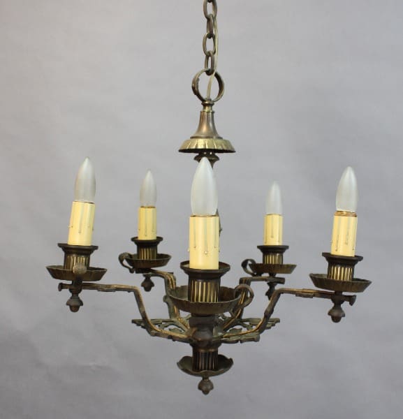 15384. Brass 1920's Chandelier With Original Finish with five candle-like light bulbs, suspended by a chain against a plain gray background.