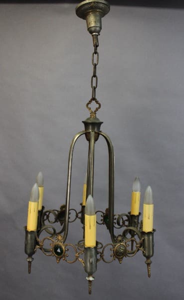 15387. 1920's Spanish Revival Chandelier With Jewels with five candle-like bulbs and ornate metalwork, hanging against a grey backdrop.
