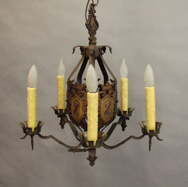 15396. 1 of 2 Spanish Revival Chandelier With Shield Motif with six candle-shaped bulbs and ornate metal designs, suspended from a chain against a neutral background.
