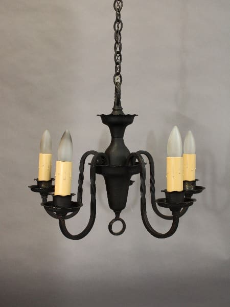 A 15418. 1920's Simple 5 Light Chandelier with five arms, each holding a white candle-shaped bulb, hanging from a chain against a gray background.