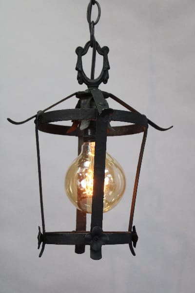 15439. Circa 1920's Simple Pendant With One Bulb with a glowing filament bulb, set against a plain, light gray background.