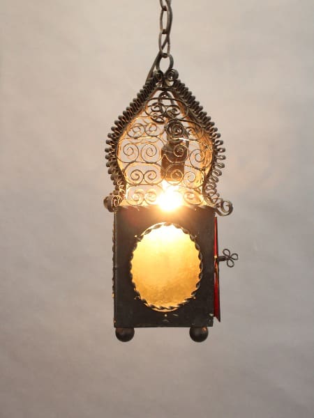 15442. Whimsical pendant hanging from a chain, illuminated from within, casting a warm glow through its oval glass panel.