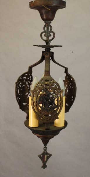 Antique hanging lamp with an ornate metal frame, featuring intricate cut-out patterns and a central yellow glass shade. 
Product Name: 15489. Polychrome Pendant With Galleon Motif