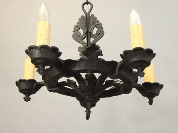 15547. Circa 1920's Five Light Chandelier With Simple Lines with two illuminated candle-shaped bulbs and ornate floral designs, against a plain background.