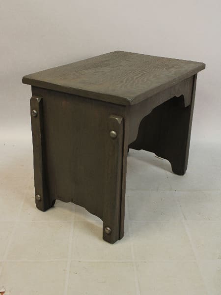 A simple 15642. Smal Restored 1930's Bench with a dark finish and an arch-shaped cutout on one side, standing on a plain, light-colored floor against a light background.