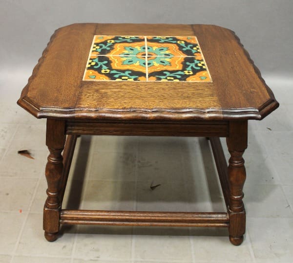 15857. 1920's California Tile Table with a colorful ceramic tile inlay on top, featuring floral patterns, positioned on a gray surface.