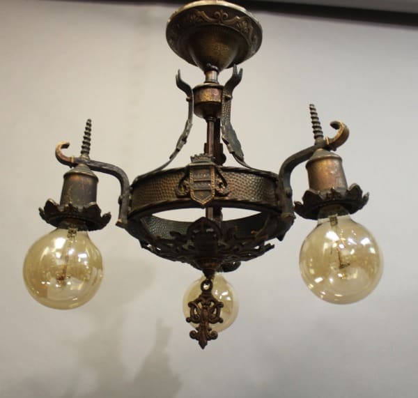 15919. 1 of 2 1920's Ceiling Light Chandelier With Three Bulbs with ornate metal detailing hanging from a ceiling.