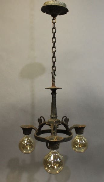 15921. Spanish Revival Tudor Three Light Small Chandelier with three glass globes hanging from a metal chain, casting a shadow on a light background.