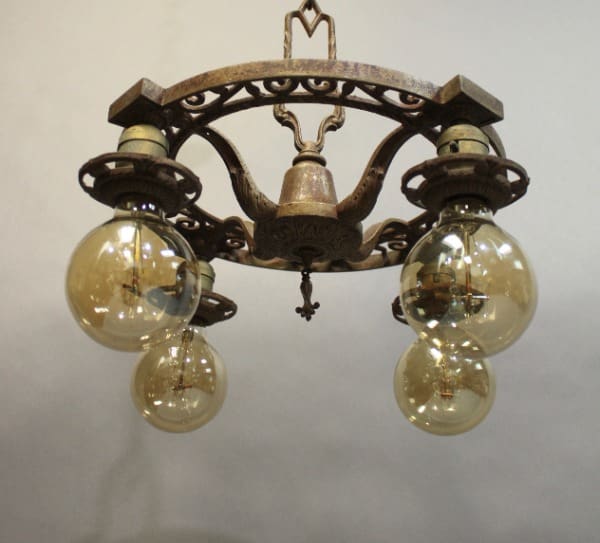15922. Four Light Downlight Chandelier Circa 1920's with ornate metal frame and three large, round glass bulbs, hanging against a plain, light background.