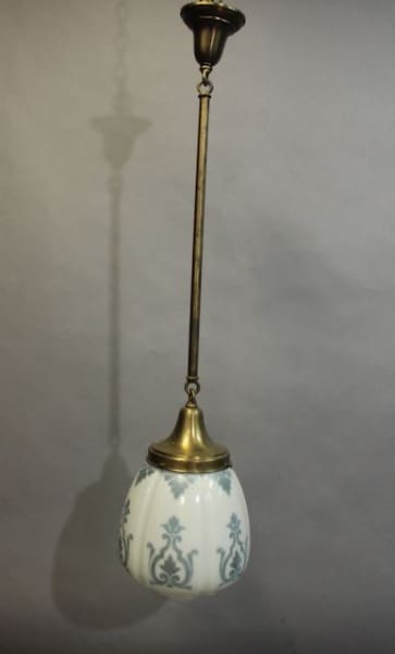 16024. 1 of 5 Glass Pendants Circa 1920's with a brass fixture and a white glass shade decorated with blue floral patterns hanging against a gray background.
