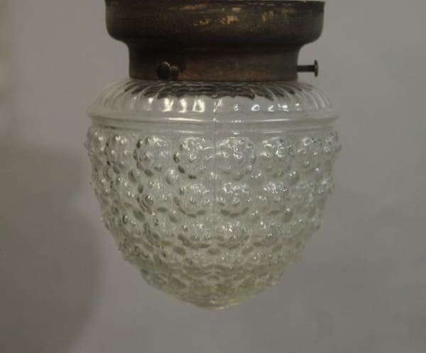 Antique Ceiling Mount Fitter with Glass Shade with a textured bubble pattern, attached to a dark metal fixture.