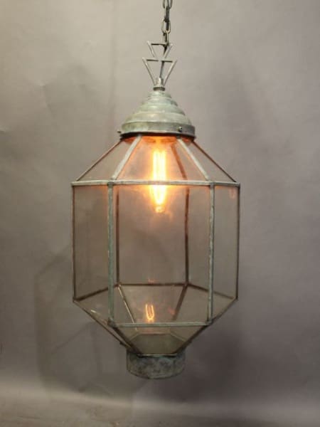 A hanging 16217. Simple Verdigris Color Pendant With Deco Line with a metal top and clear glass panels emitting a warm light.