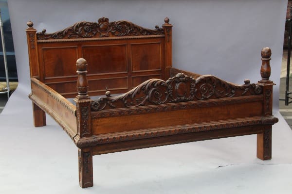 13113. European Carved Walnut Bed with ornate headboard and footboard, featuring detailed carvings and turned bedposts, displayed against a plain backdrop.
