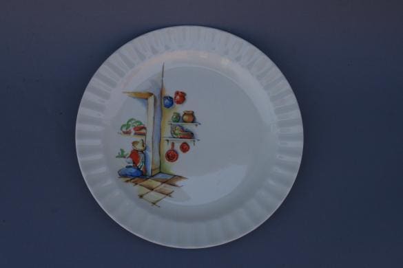 Decorative plate with a painted illustration of a food market scene, including fruits and a merchant, set against a plain blue background from the 3221. Set Of 12 Spanish Revival Plates.