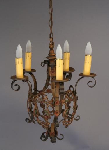 3505. Charming Chandelier w/ Polychrome Finish with five electric candle bulbs, featuring intricate metal scrollwork and a faded gold finish, hanging against a gray background.